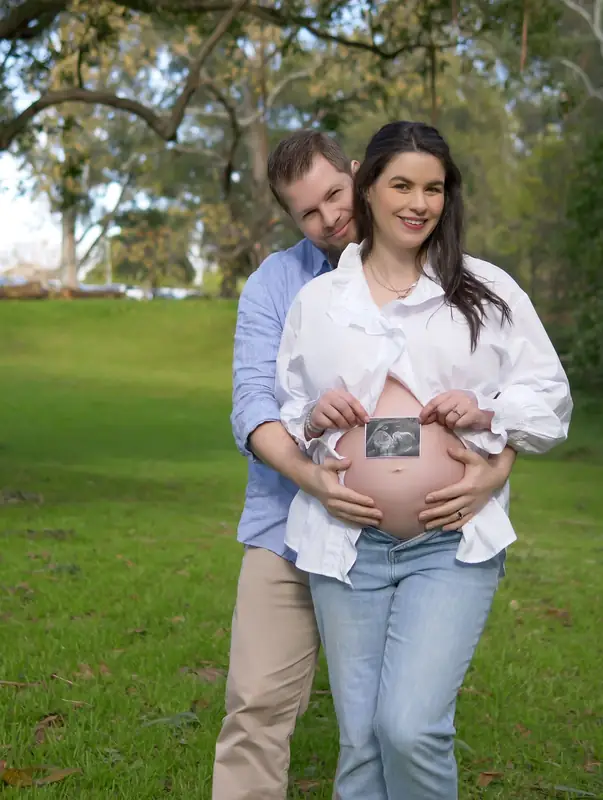 Expecting parents holding a tiny pair of shoes