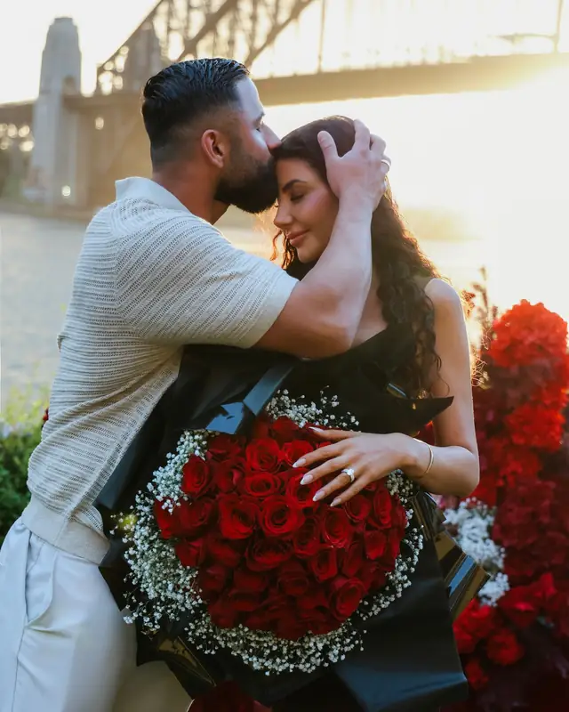 Couple embracing with a red bouquet