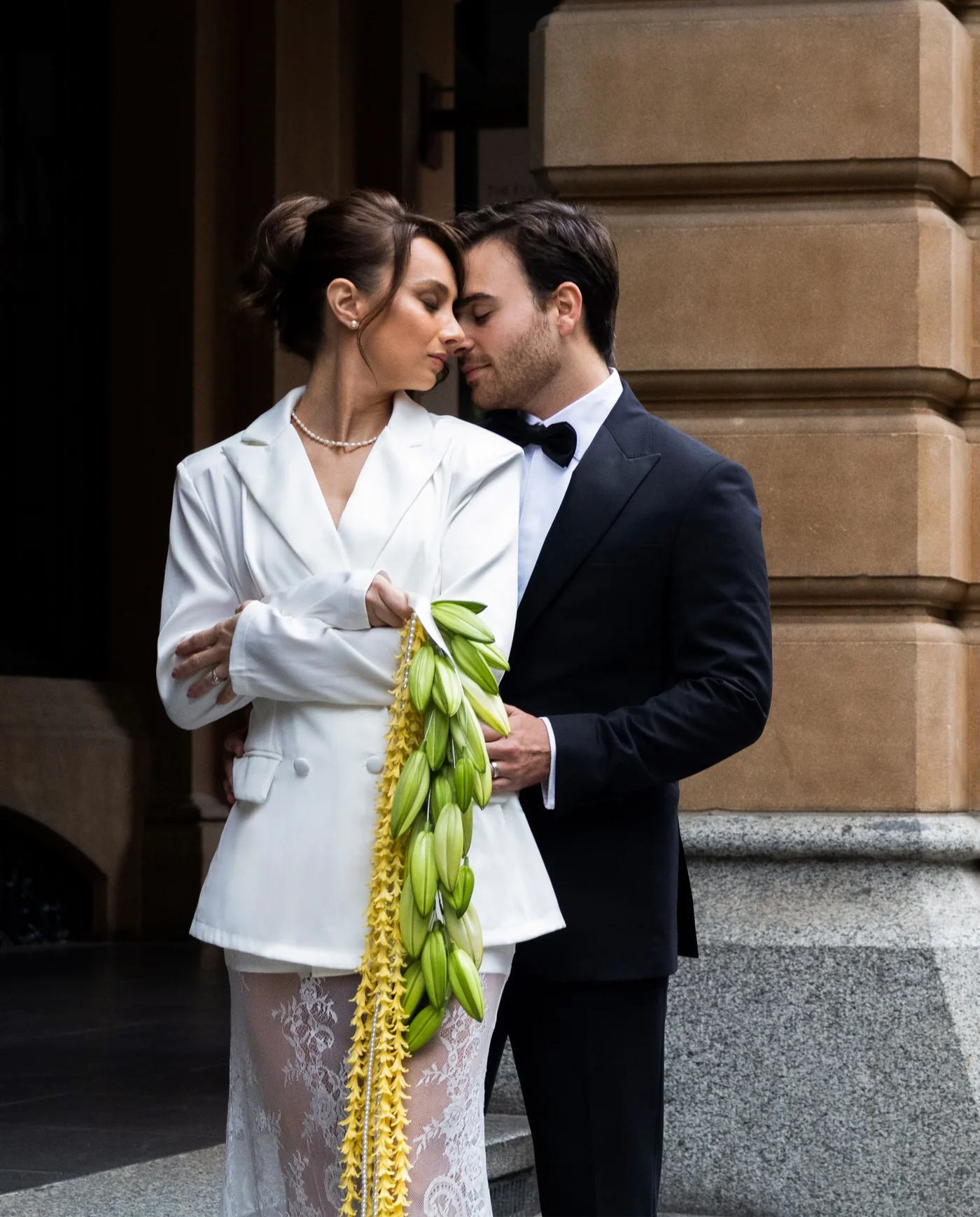 Sofi and Daniel embrace in city wedding attire.
